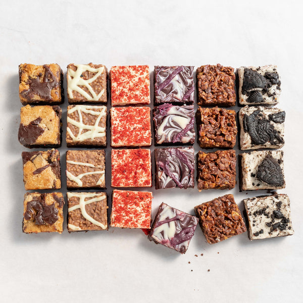 An array of colourful and vibrant flavoured brownies with various toppings and fillings, arranged in a grid pattern to represent a box of diverse flavored bites.