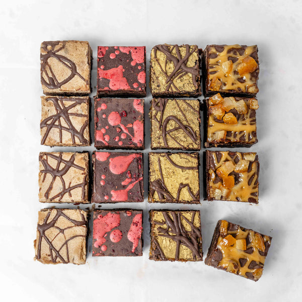 Four different flavours of vegan and gluten free chocolate brownies on a white surface