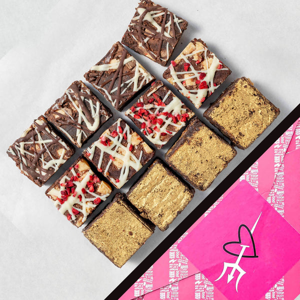 Assorted brownies in a box with a pink and white design on a light gray background
