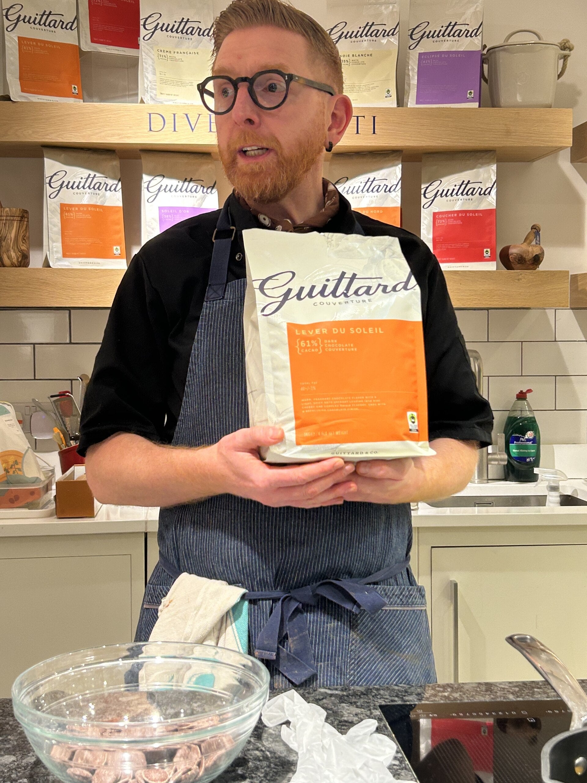 Paul A Young holding a Bag of Guittard chocolate