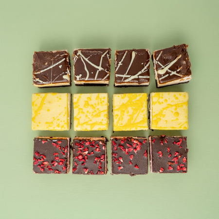Nine square slices of different flavour marshmallow chocolate brownies arranged in a 3x3 grid on a green background.