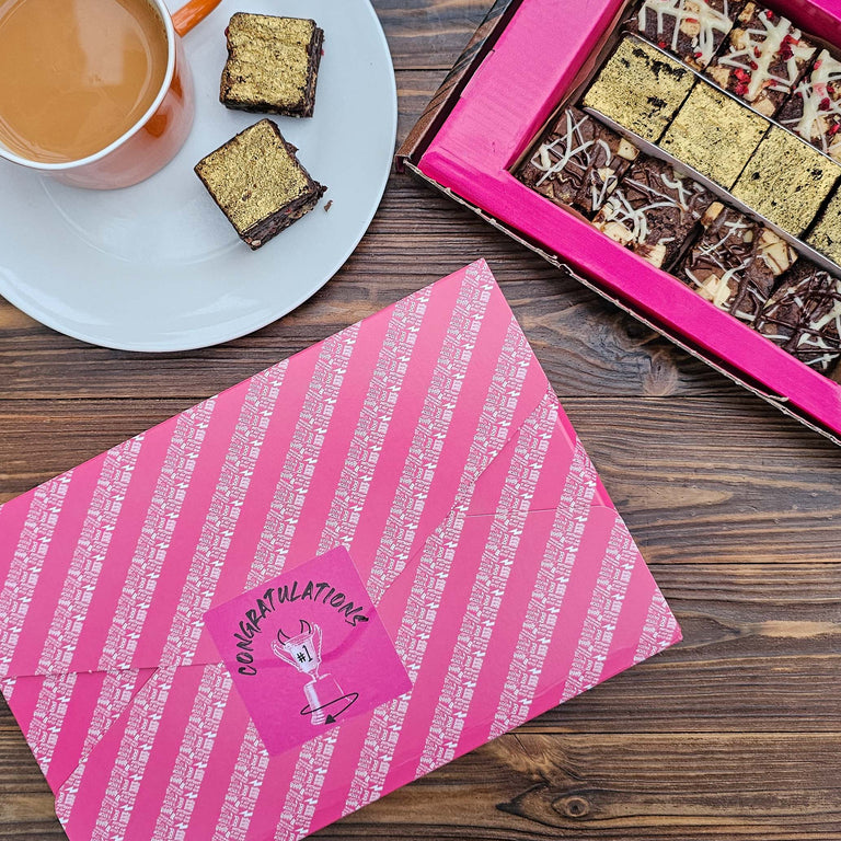 wrapped chocolate brownies saying Congratulations on a table with an open box of chocolate brownies and tea next to it