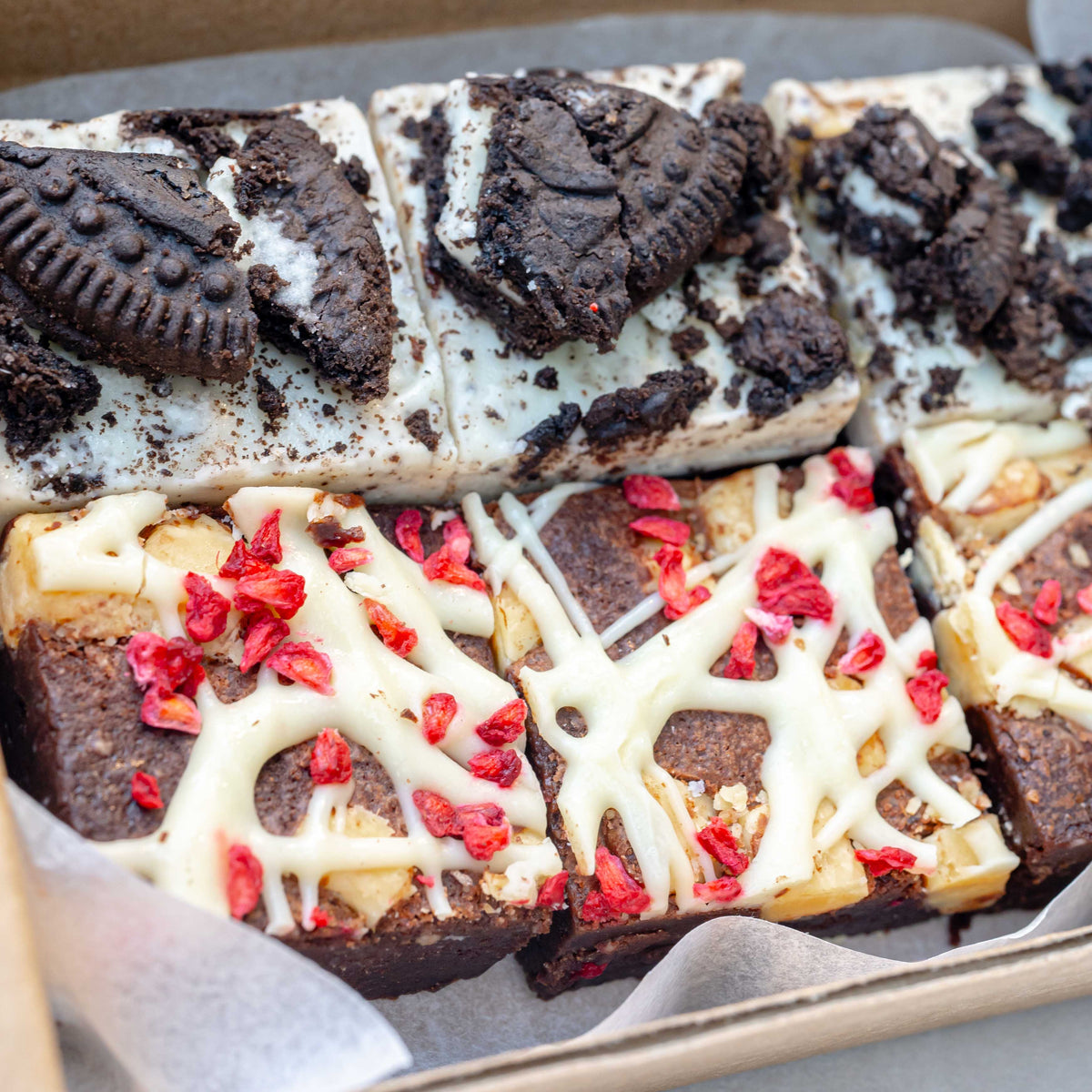 raspberry white chocolate brownies and Oreo cookies and cream brownies in a postal brownie box