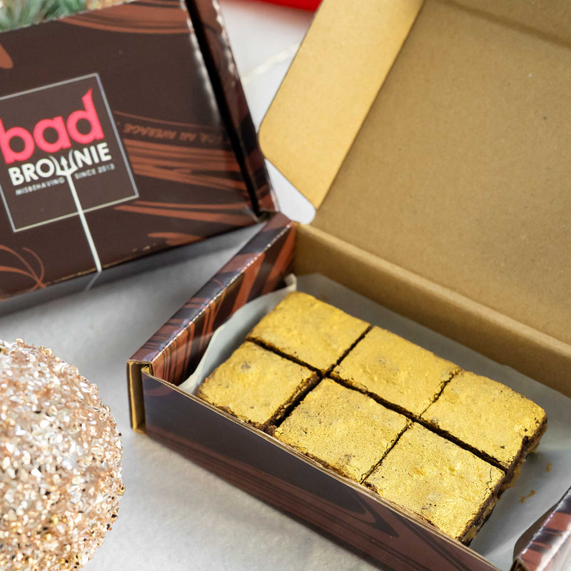 Box of bad brownie with salted caramel brownies inside on a light surface