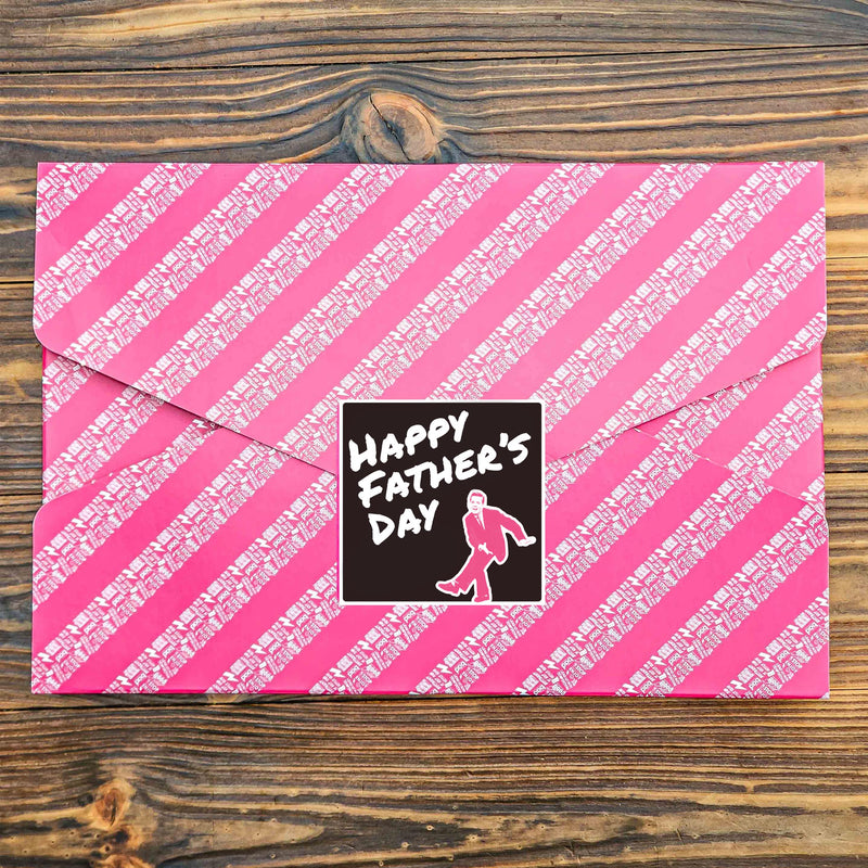 Pink gift wrapped box of brownies with a black Happy Father's Day Sticker, on a wooden tabletop