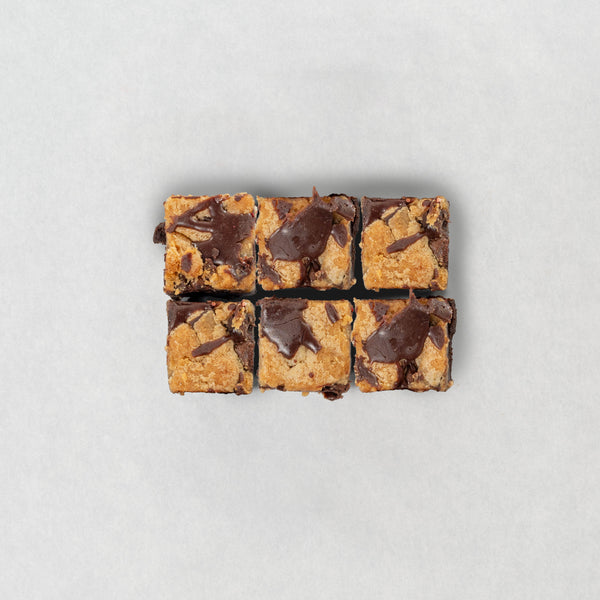 Chocolate brownie and cookie brookie cut into squares on a light gray background