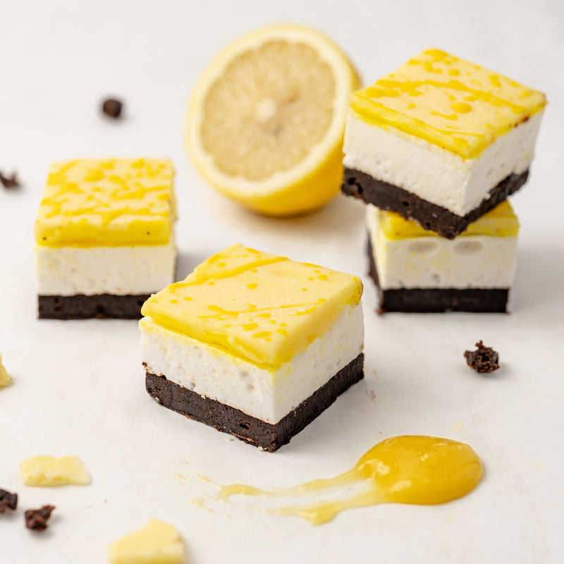 Lemon-flavored marshmallow chocolate brownie with a lemon and chocolate pieces on a white background