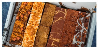 A tray of assorted Bad Brownie squares in an open gift box